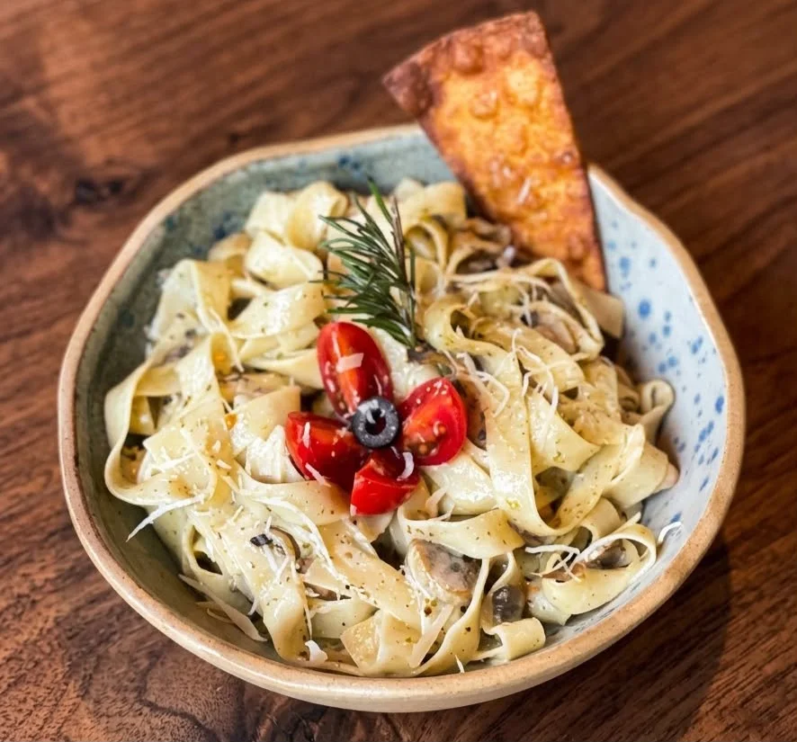 Fettuccine Alfredo with pesto sauce, chicken, and mushrooms